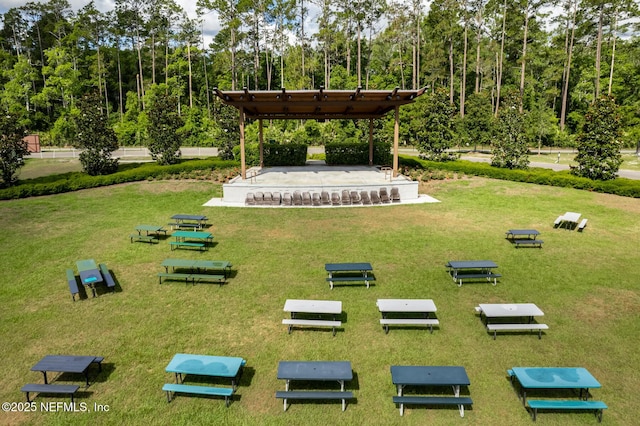 view of community featuring a pergola and a lawn