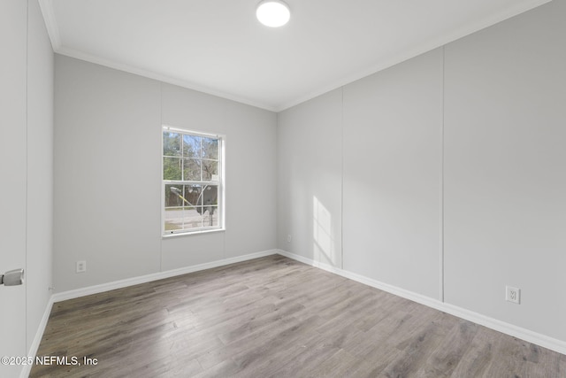 spare room featuring ornamental molding and hardwood / wood-style floors