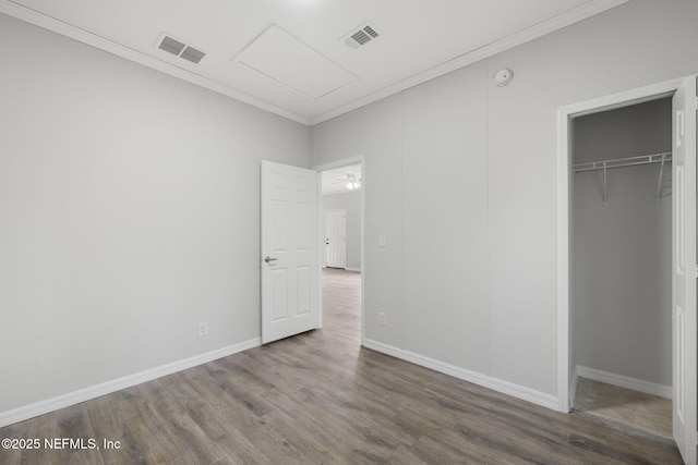 unfurnished bedroom with ornamental molding, hardwood / wood-style floors, and a closet