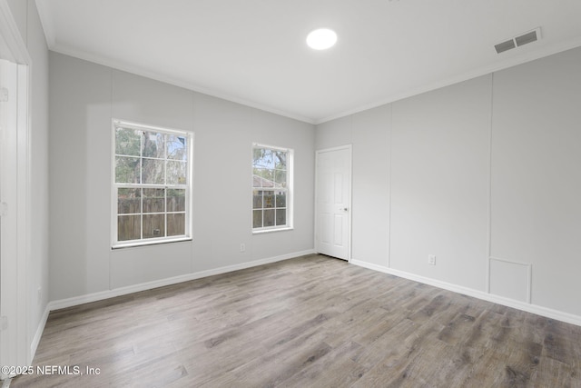 spare room with crown molding and hardwood / wood-style floors