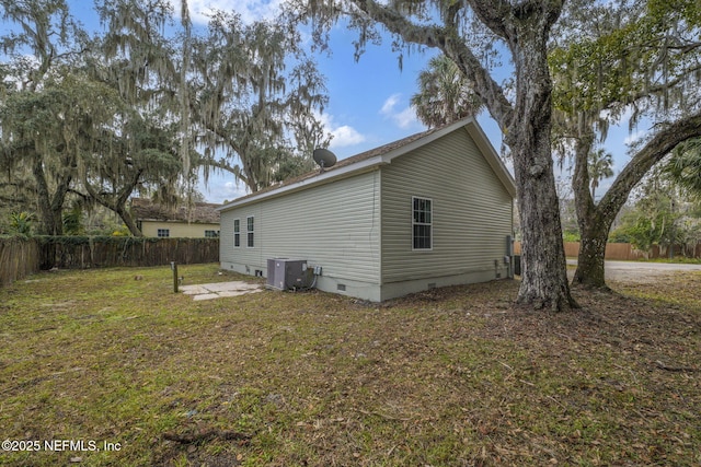 rear view of property featuring central air condition unit and a lawn