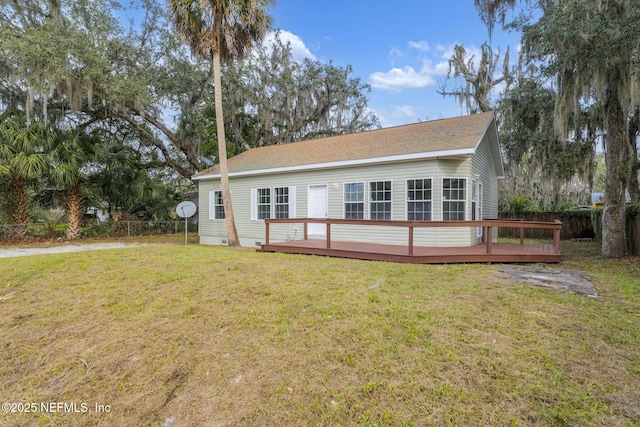 rear view of property with a lawn and a wooden deck