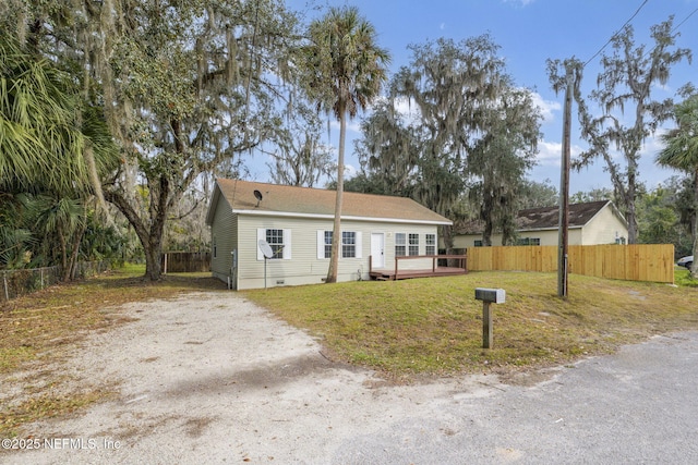 ranch-style home featuring a deck and a front lawn