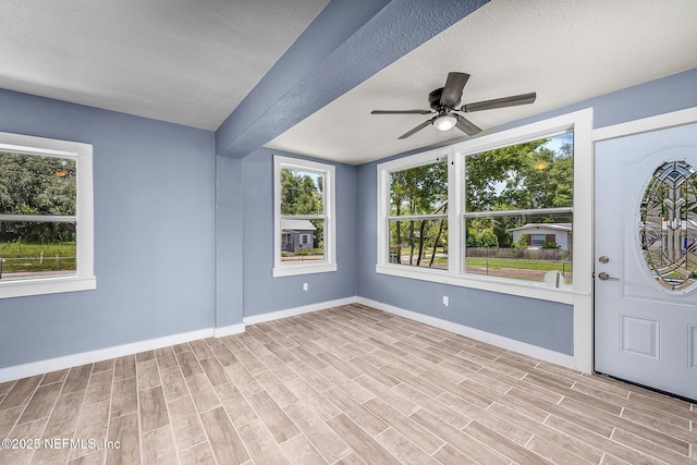 foyer entrance featuring ceiling fan, a textured ceiling, and light wood-type flooring