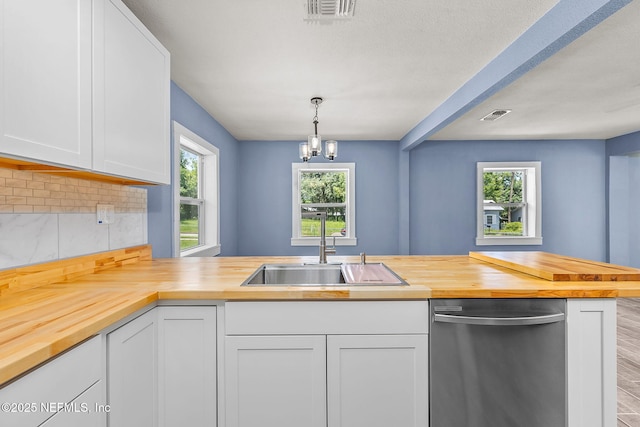 kitchen with white cabinetry, kitchen peninsula, butcher block countertops, dishwasher, and pendant lighting