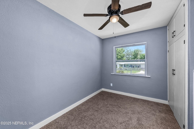 unfurnished room with ceiling fan and carpet