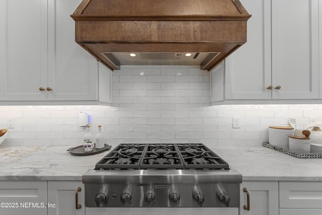 264 N Roscoe Blvd, Palm Valley, FL 32082 - kitchen with custom range hood, stainless steel gas stovetop, light stone countertops, decorative backsplash, and white cabinets