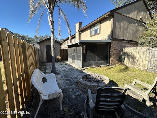 7020 Prestwick Cir N, Jacksonville, FL 32244 - back of property with a fire pit, a shed, a fenced backyard, an outdoor structure, and a patio area