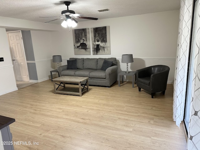 7020 Prestwick Cir N, Jacksonville, FL 32244 - living area with visible vents, baseboards, ceiling fan, light wood-style floors, and a textured ceiling