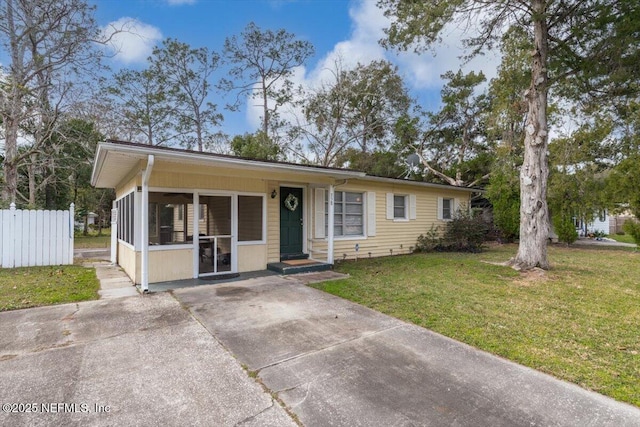 view of front of home with a front yard and a sunroom