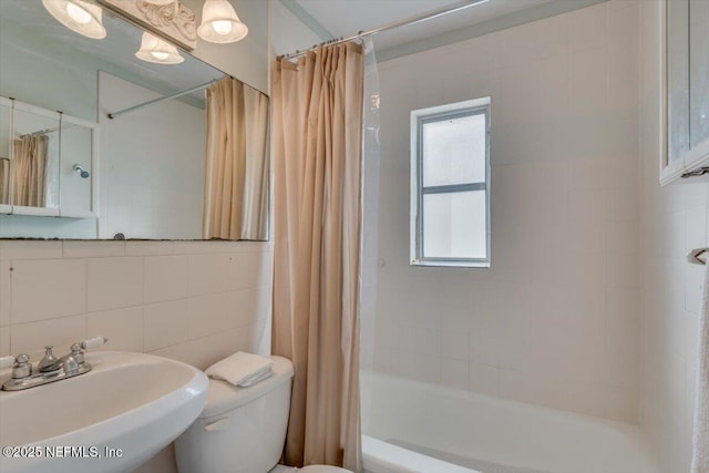 full bathroom with shower / bath combination with curtain, toilet, tile walls, sink, and backsplash