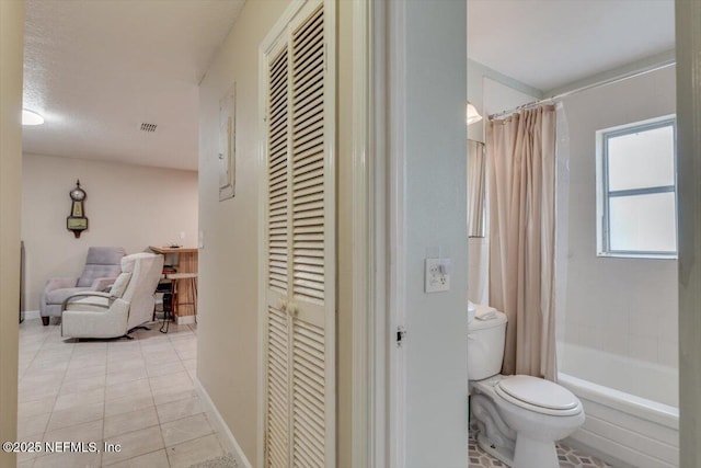 bathroom featuring toilet, tile patterned floors, and shower / bath combo