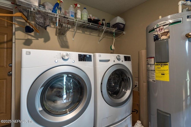 laundry room with a textured ceiling, washer and clothes dryer, and electric water heater