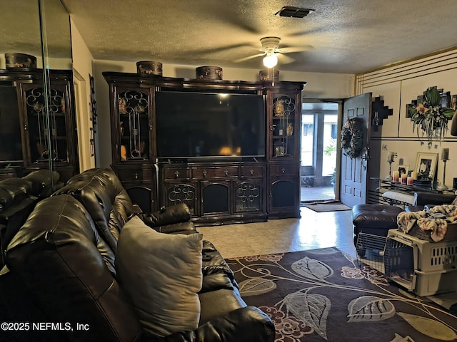 living room featuring a textured ceiling and ceiling fan