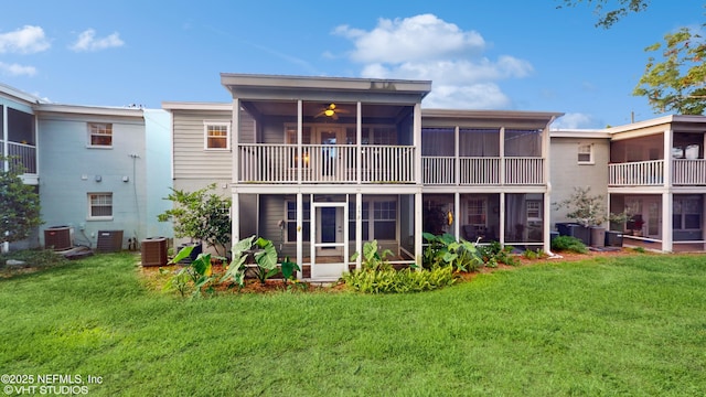 rear view of house with a sunroom, a yard, and central AC unit