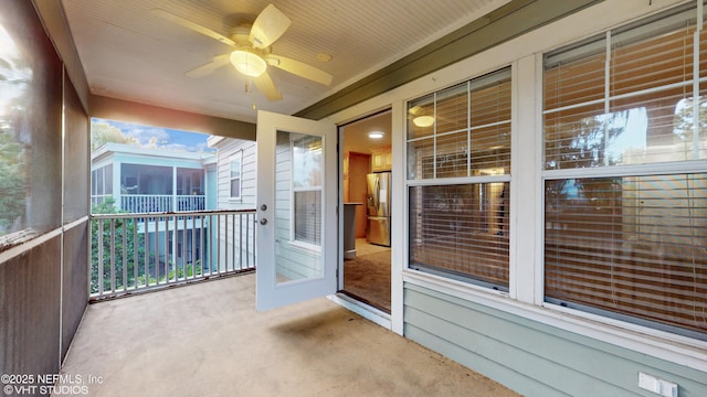 unfurnished sunroom featuring ceiling fan and a healthy amount of sunlight