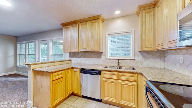 kitchen featuring kitchen peninsula, stainless steel appliances, backsplash, light tile patterned flooring, and sink