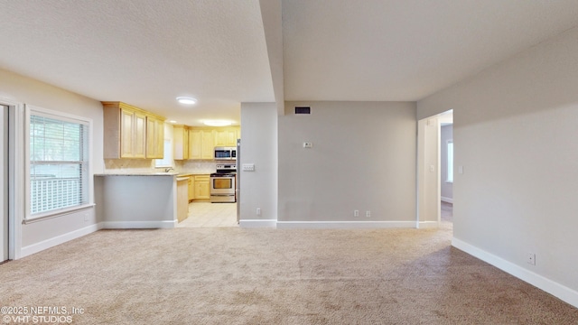 unfurnished living room featuring light carpet