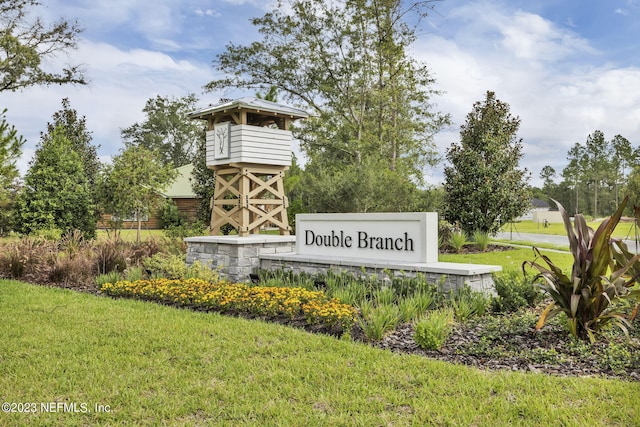 community / neighborhood sign with a yard