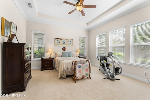 carpeted bedroom featuring ornamental molding, ceiling fan, and a raised ceiling