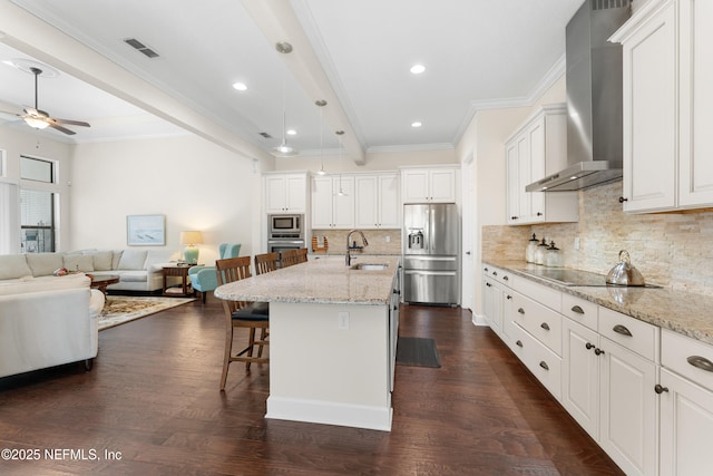 kitchen with an island with sink, stainless steel appliances, a breakfast bar, white cabinets, and wall chimney exhaust hood