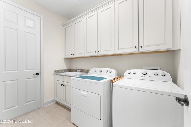 laundry room featuring light tile patterned flooring, cabinets, sink, and washing machine and clothes dryer