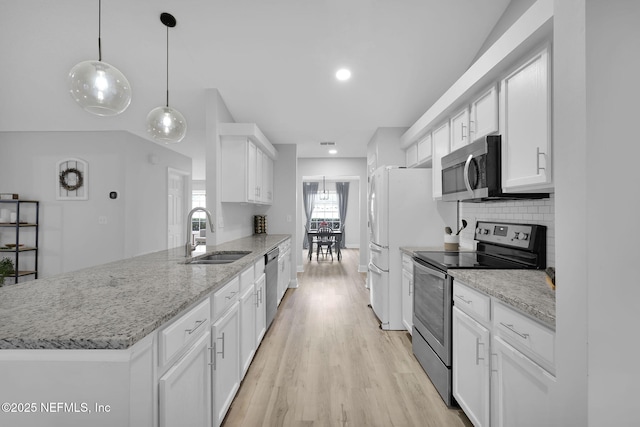 kitchen with hanging light fixtures, decorative backsplash, white cabinets, appliances with stainless steel finishes, and sink