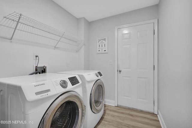 washroom with washer and dryer and light hardwood / wood-style floors