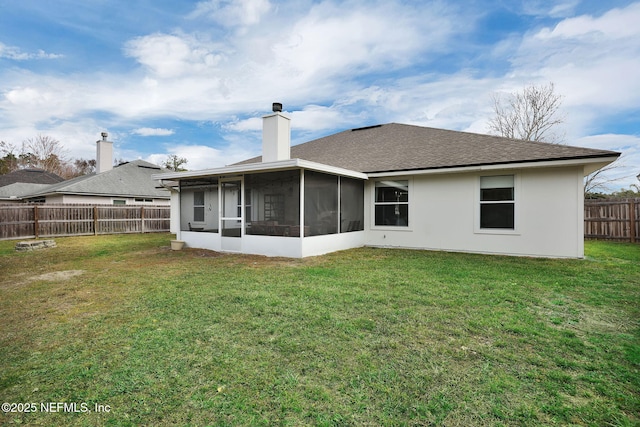 back of house featuring a sunroom and a lawn