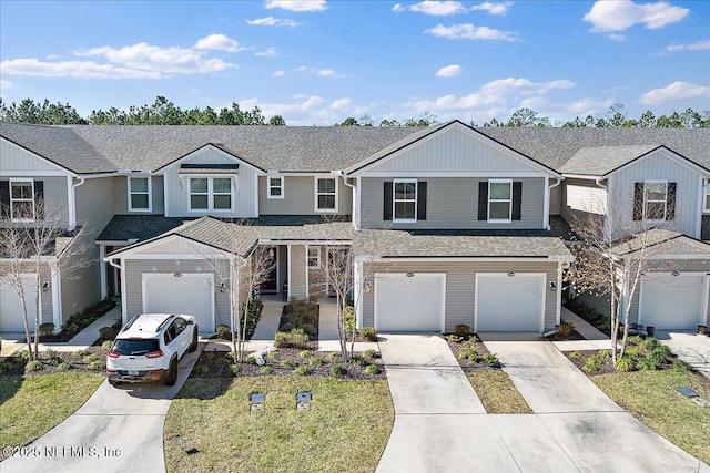 traditional home with concrete driveway, a shingled roof, and an attached garage