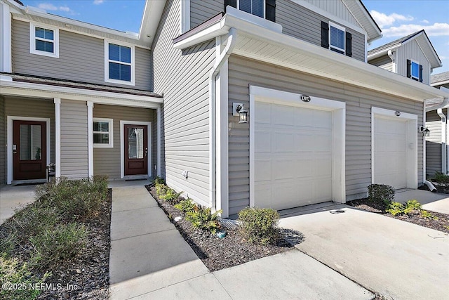 exterior space featuring board and batten siding, driveway, an attached garage, and a porch