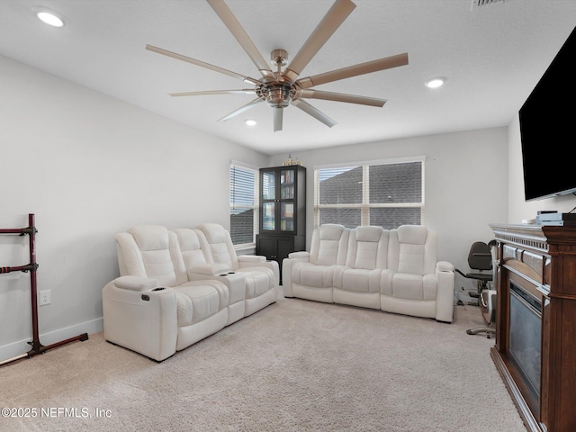 carpeted living room with ceiling fan