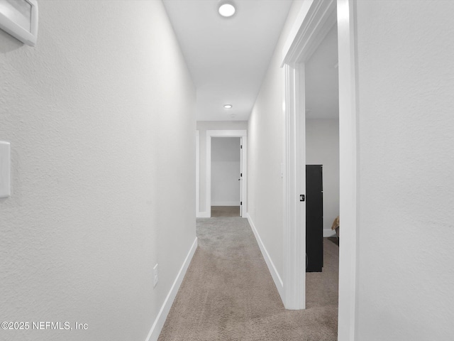 hallway with light colored carpet