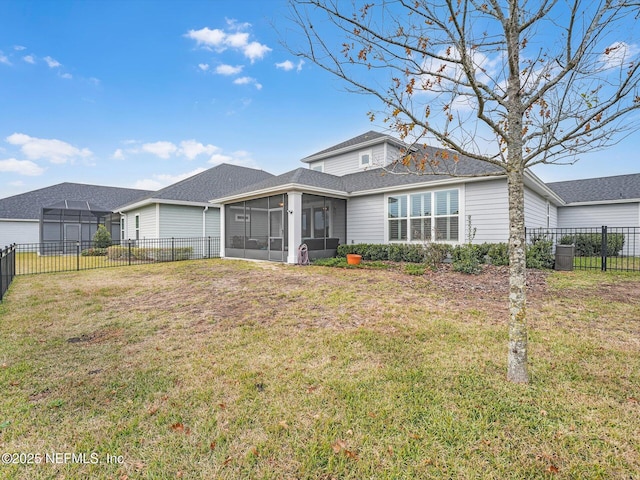 rear view of property featuring a yard and a sunroom