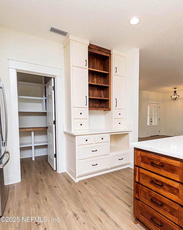 kitchen featuring light wood-type flooring and white cabinets