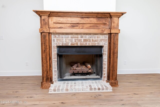 interior details featuring a brick fireplace and hardwood / wood-style flooring