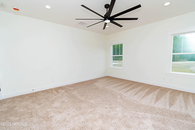 carpeted spare room with ceiling fan and a wealth of natural light