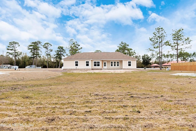 rear view of property featuring a lawn