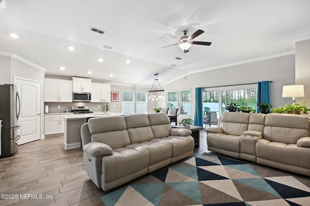 living room featuring vaulted ceiling, ceiling fan, ornamental molding, sink, and light hardwood / wood-style flooring