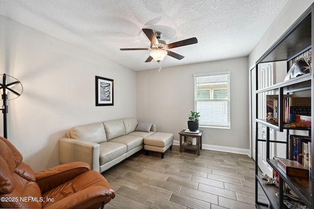 living room featuring ceiling fan and a textured ceiling