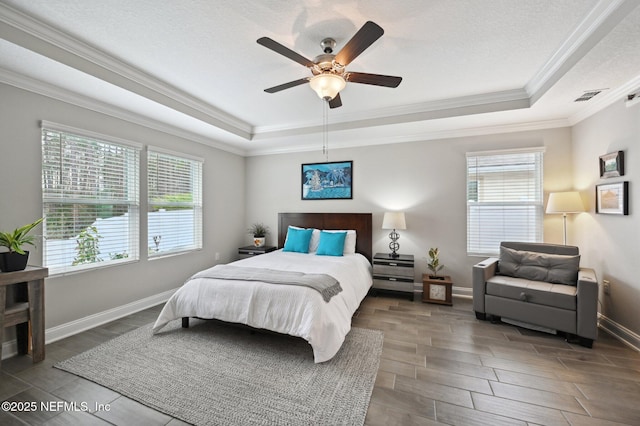 bedroom with ceiling fan, ornamental molding, and a tray ceiling