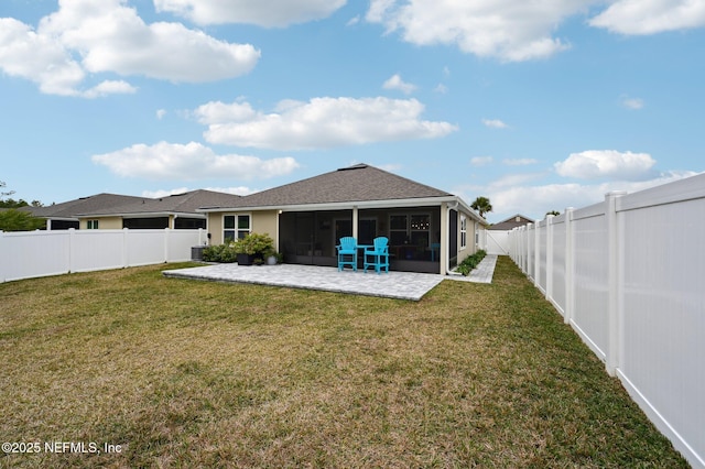 rear view of property featuring a patio area, a sunroom, and a yard