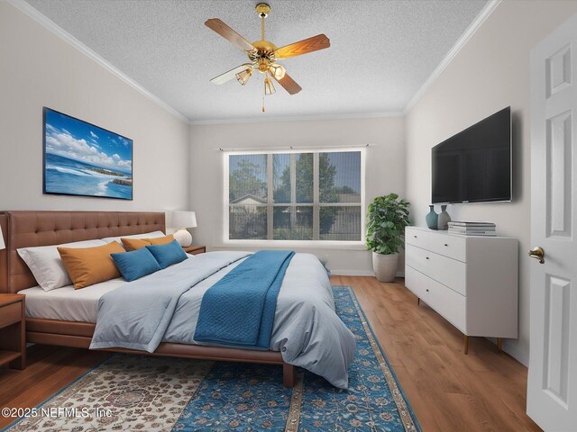 bedroom featuring crown molding, a textured ceiling, ceiling fan, and light wood-type flooring