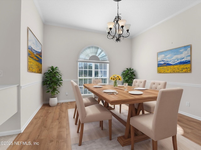 dining room with crown molding, a notable chandelier, and light hardwood / wood-style flooring