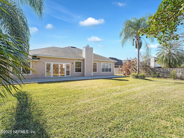 rear view of property with a yard and a patio