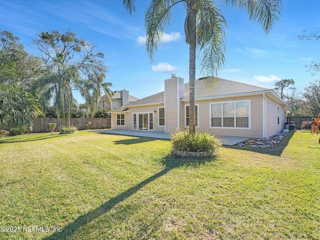 back of house with a patio and a lawn