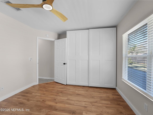 unfurnished bedroom with light hardwood / wood-style flooring, a closet, and ceiling fan