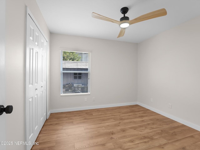 empty room with ceiling fan and light hardwood / wood-style flooring