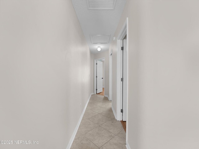 hallway with light tile patterned flooring and a textured ceiling