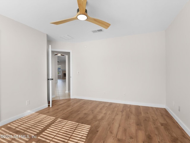 empty room with ceiling fan and light hardwood / wood-style flooring